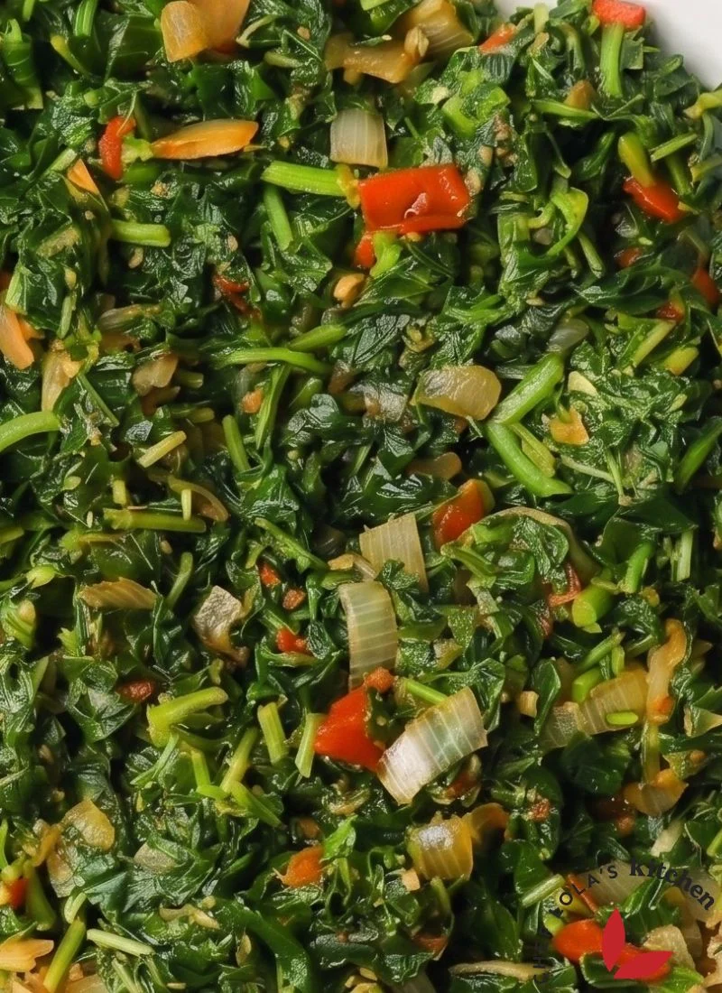 Primer plano de callaloo jamaicano sazonado cocinado hasta que esté tierno y sabroso.