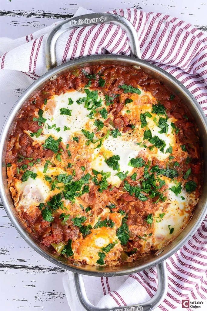 Shakshuka saludable elaborado con huevos escalfados en una sabrosa salsa de tomate y pimiento.