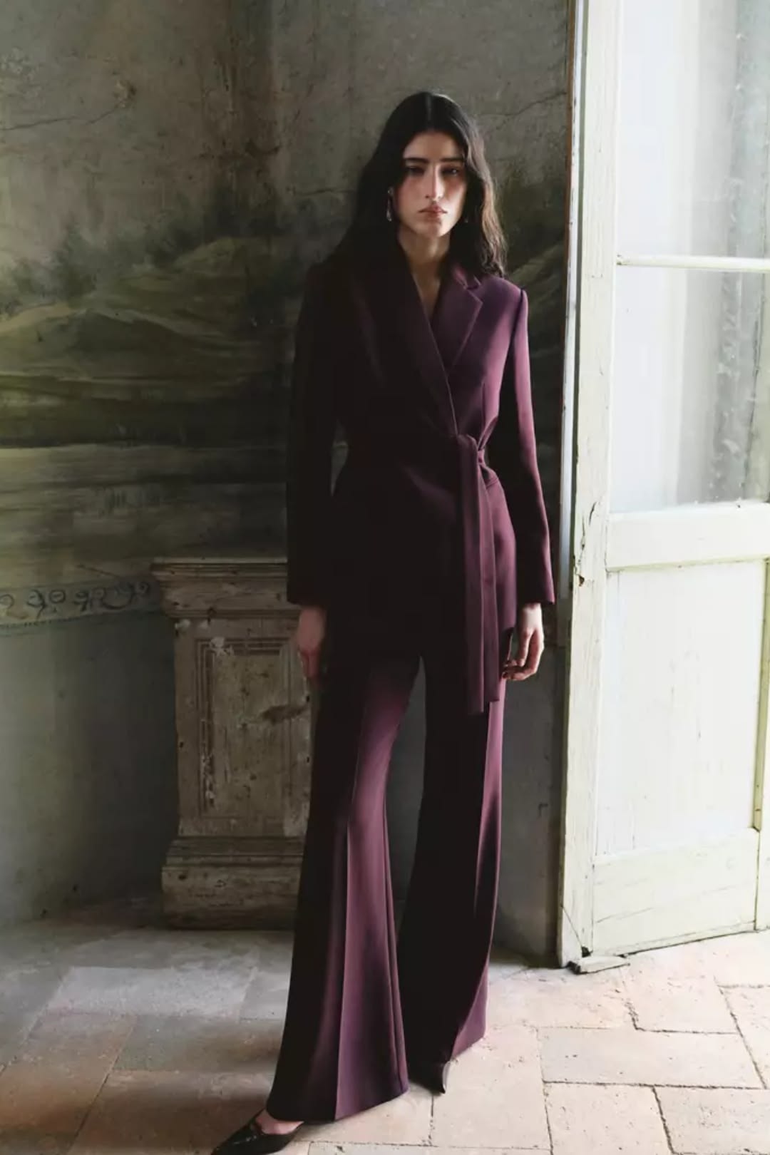 Mujer vistiendo traje pantalón morado ciruela para el otoño.